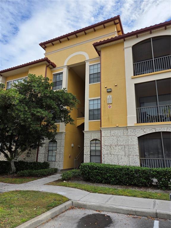6157 Metrowest Boulevard, Unit 304 Orlando, FL 32835 - Photo 2 of 13 a front view of a house with a yard