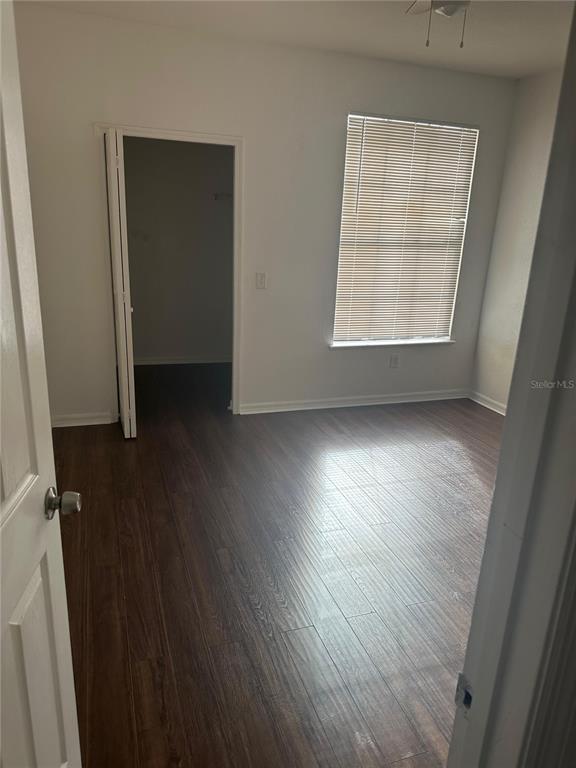 6157 Metrowest Boulevard, Unit 304 Orlando, FL 32835 - Photo 4 of 13 an empty room with wooden floor and windows