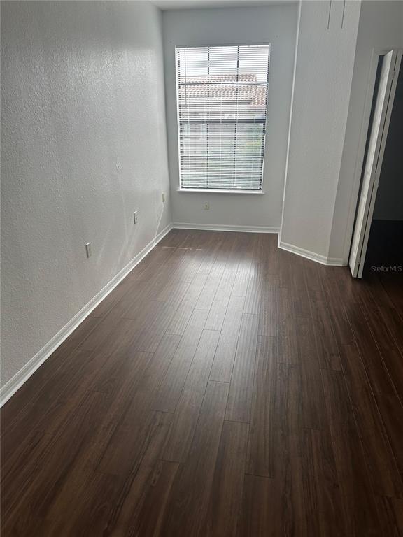 6157 Metrowest Boulevard, Unit 304 Orlando, FL 32835 - Photo 7 of 13 an empty room with wooden floor and windows