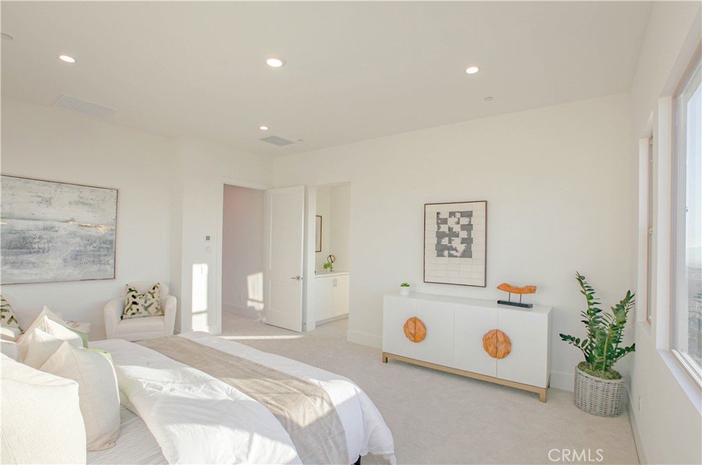 137 Oakstone Irvine, CA 92618 - Photo 8 of 23 a bedroom with a bed a white wall and a potted plant