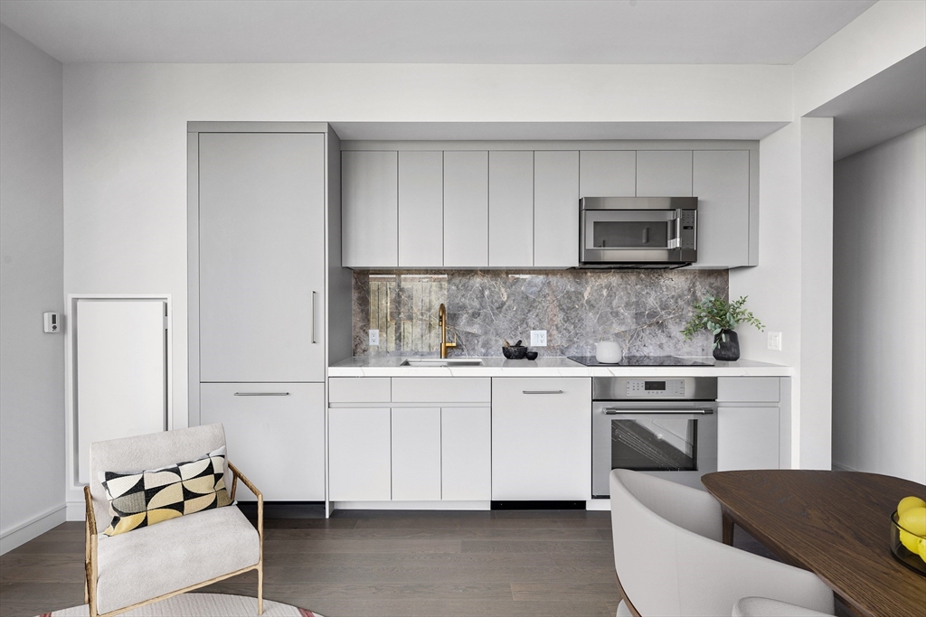 55 Lagrange Street, Unit 1607 Boston, MA 02111 - Photo 2 of 16 a kitchen with stainless steel appliances white cabinets and a stove top oven