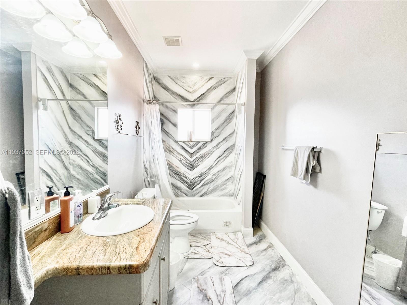 1102 Northwest 26th Street, Unit 1102 Miami, FL 33127 - Photo 17 of 39 a bathroom with a granite countertop sink and a mirror