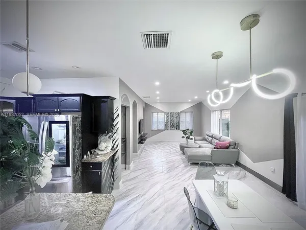 a living room with furniture a flat screen tv and potted plant