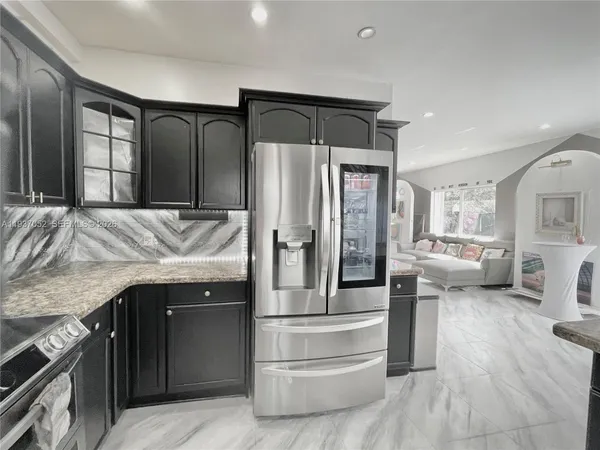 a kitchen with stainless steel appliances granite countertop a refrigerator and stove