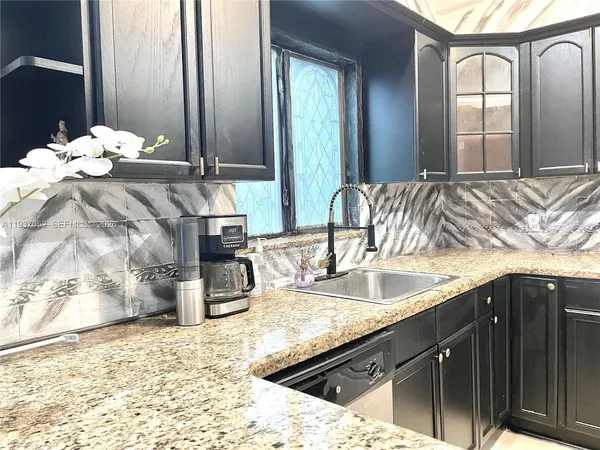 a bathroom with a sink vanity granite tub and a mirror