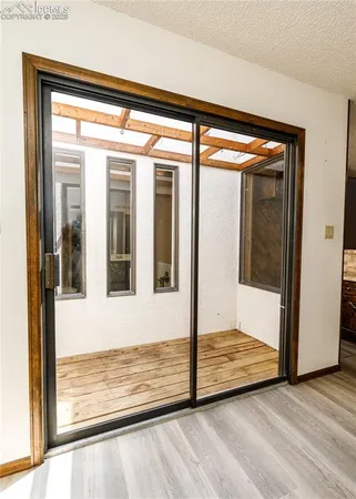 a view of an empty room and chandelier fan