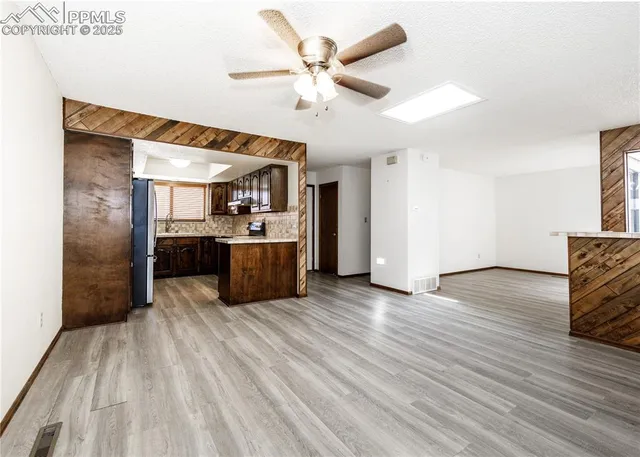 a large kitchen with stainless steel appliances a large counter top a chandelier and a view of kitchen