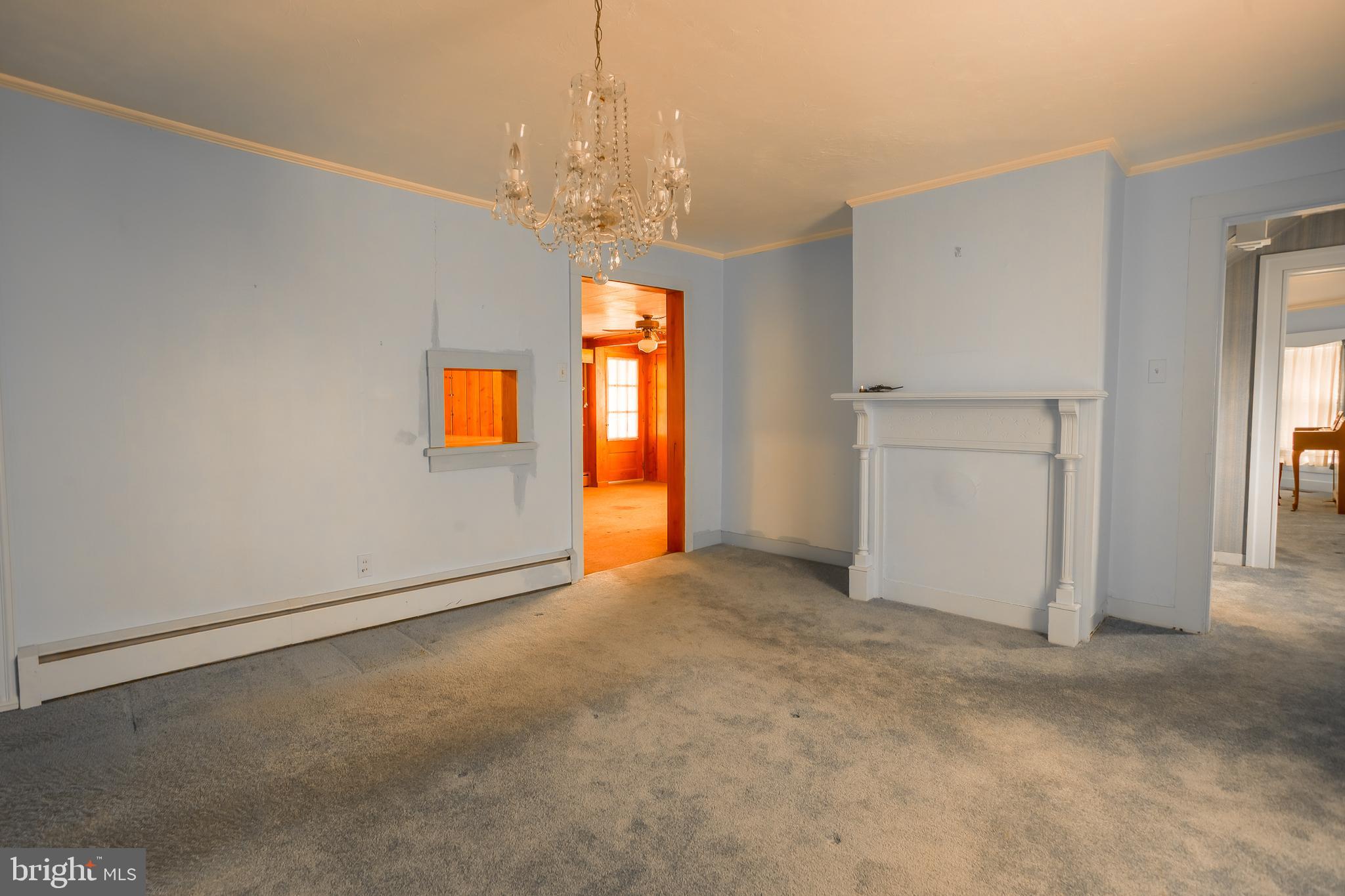 7751 Dividing Creek Road Pocomoke City, MD 21851 - Photo 38 of 51 an empty room that has a chandelier and a chandelier fan