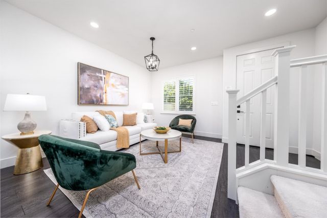 a living room with furniture a large window and wood floor