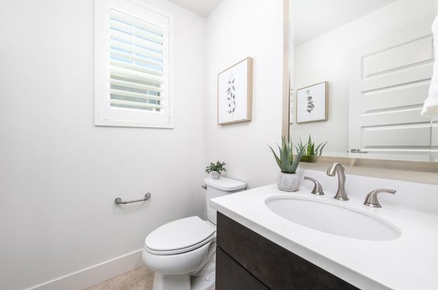 a bathroom with a granite countertop sink toilet and a mirror