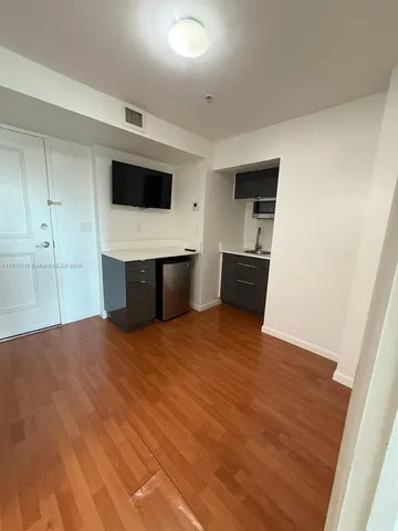 a view of a kitchen with wooden floor and electronic appliances