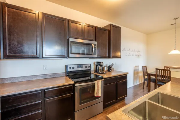 a kitchen with stainless steel appliances a stove microwave and sink