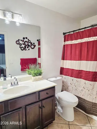 a bathroom with a sink a toilet and shower curtain