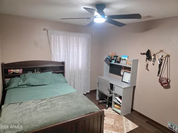 a view of a bedroom with a bed and wooden floor
