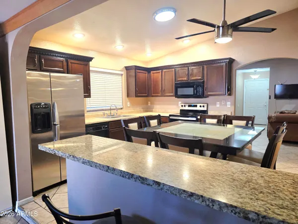 a kitchen with stainless steel appliances granite countertop a sink refrigerator and cabinets