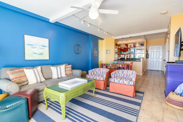 a living room with furniture a flat screen tv and a floor to ceiling window