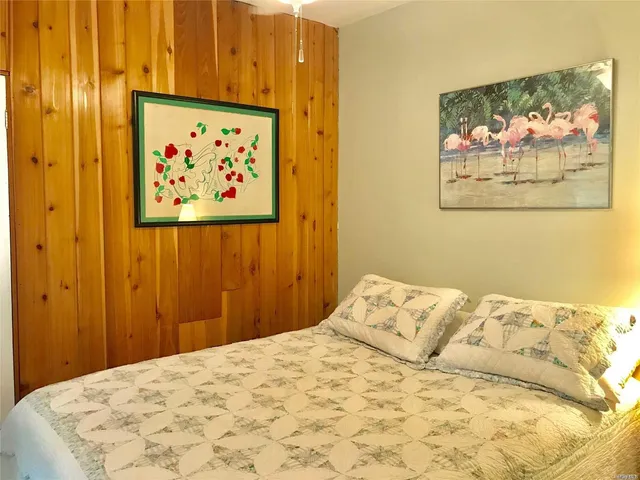 a bedroom with a bed and painting on the wall