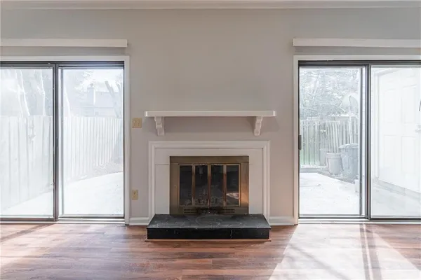 a view of empty room with wooden floor and fireplace