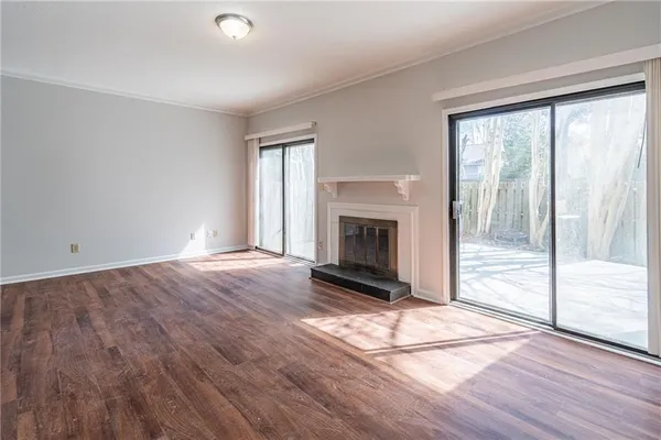 a view of a hallway with wooden floor and a window