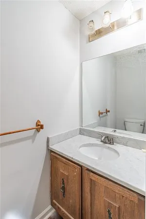 a view of a hallway with wooden floor and a bathroom