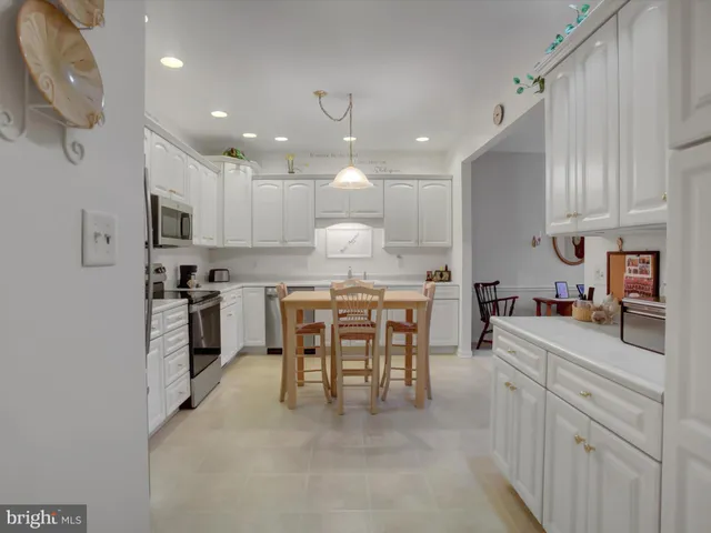 a kitchen with kitchen island granite countertop a sink a counter space stainless steel appliances and cabinets