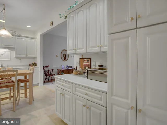 a kitchen with stainless steel appliances granite countertop a refrigerator sink and white cabinets