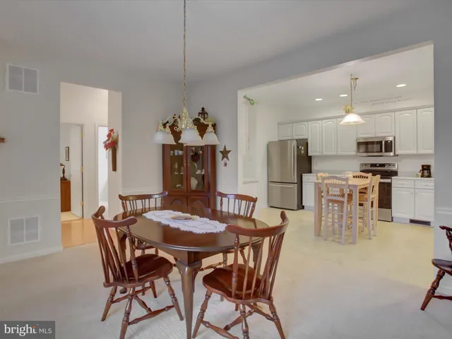 a view of a dining room with furniture and kitchen view