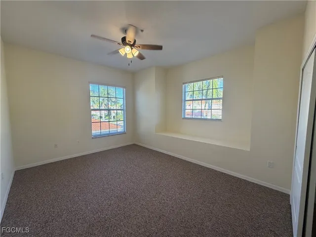 an empty room with windows and chandelier