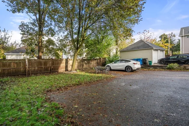 a car parked in front of a house next to a yard