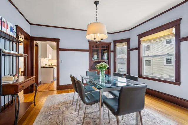 a dining room with furniture a window and wooden floor