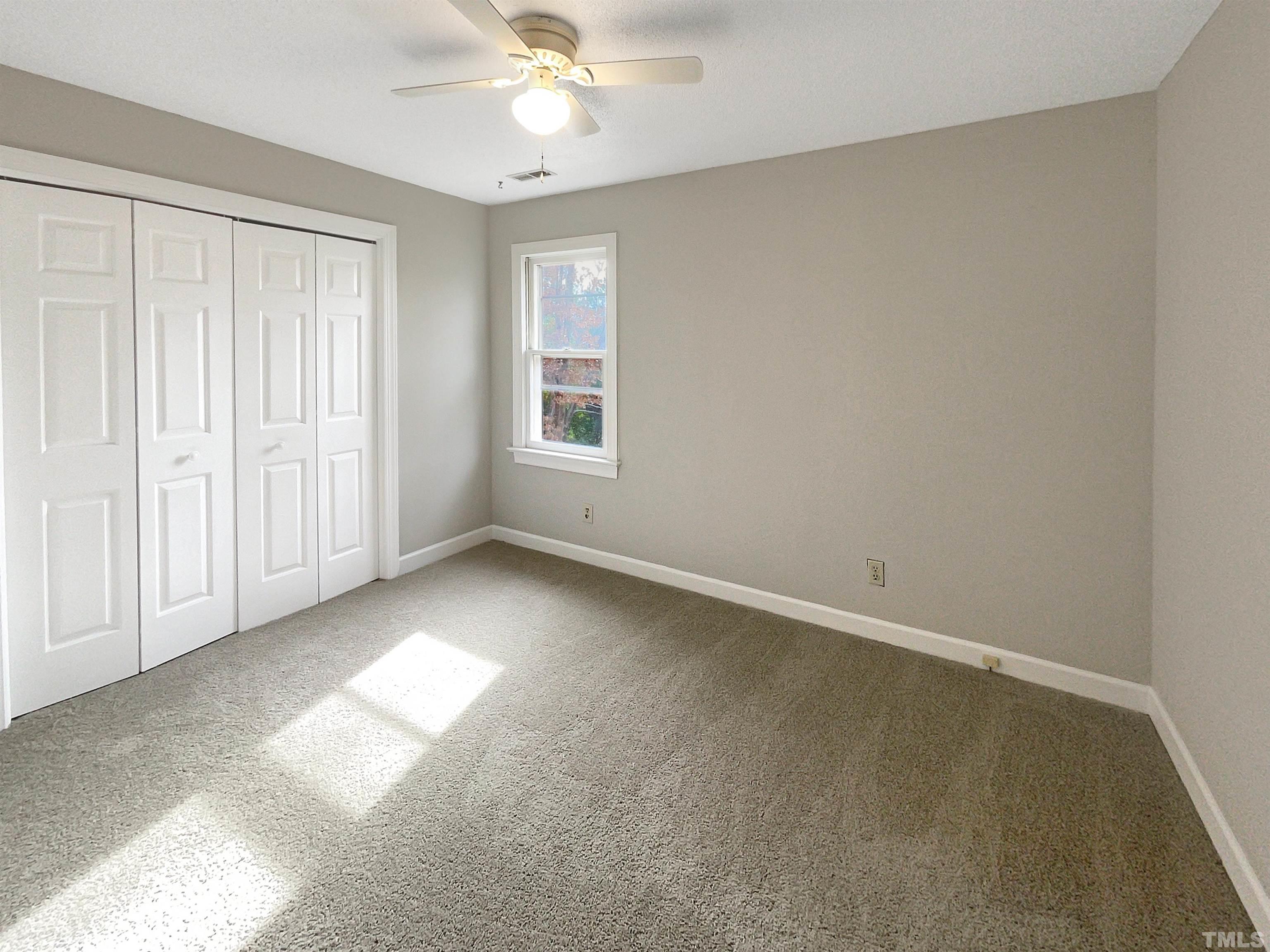 6900 Three Bridges Circle Raleigh, NC 27613 - Photo 15 of 20 an empty room with a chandelier fan and windows