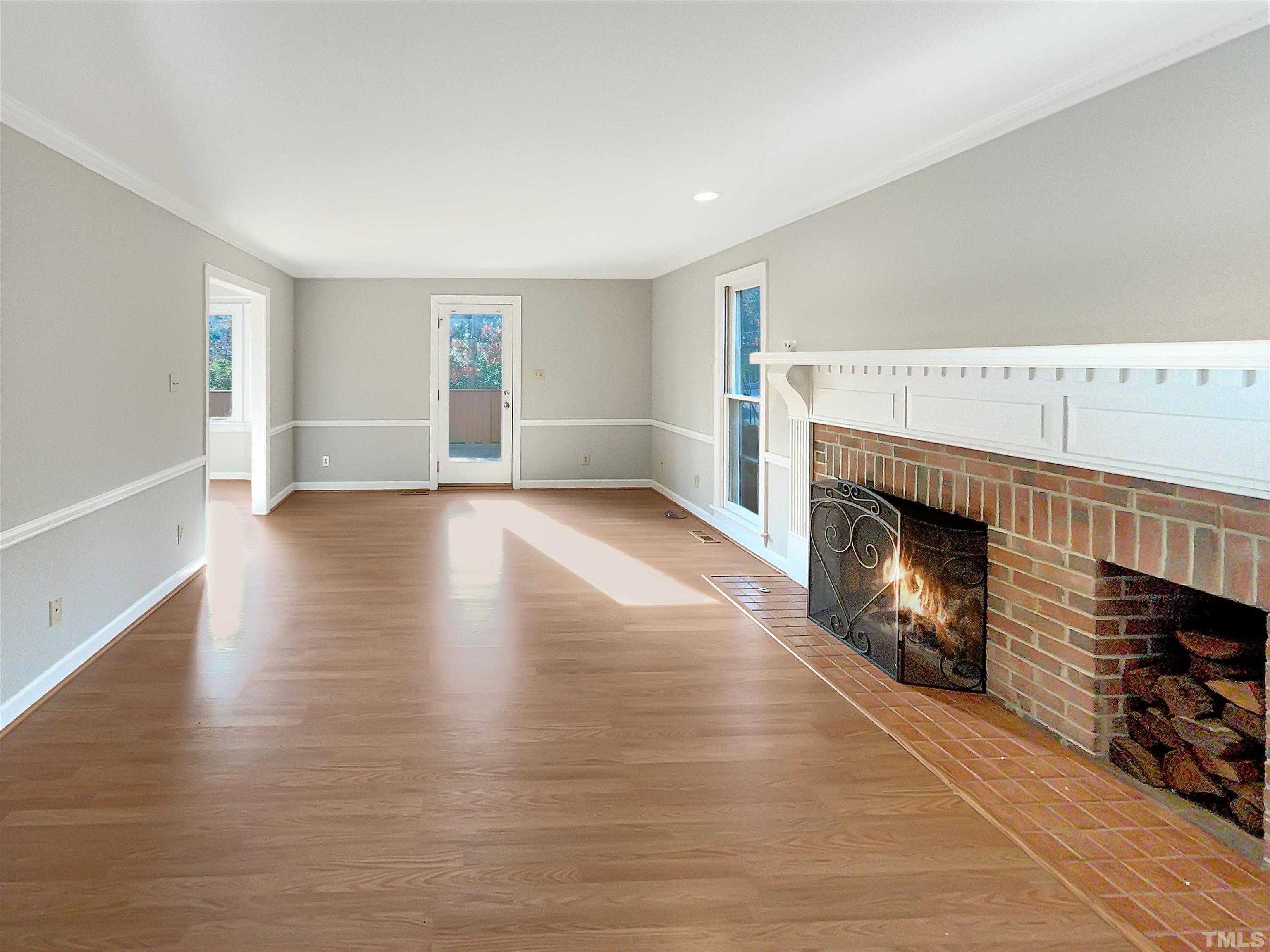 6900 Three Bridges Circle Raleigh, NC 27613 - Photo 5 of 20 a view of an empty room with wooden floor fireplace and a window