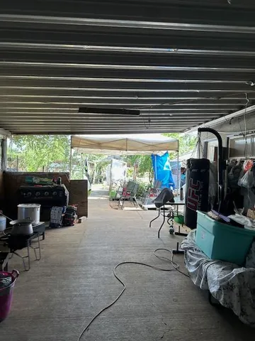 a view of a chairs and tables in the patio and a grill
