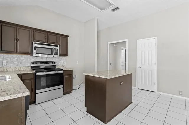 a kitchen with granite countertop a stove and a microwave