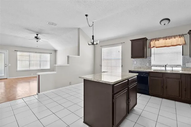 a kitchen with stainless steel appliances granite countertop a sink counter space and a window