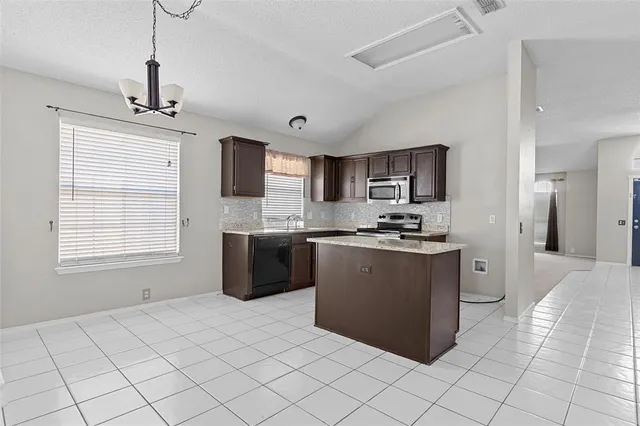 a kitchen with stainless steel appliances granite countertop a stove sink and cabinets