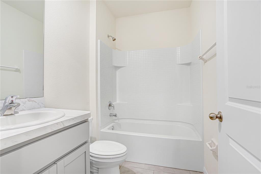 31210 Penny Surf Loop Wesley Chapel, FL 33545 - Photo 10 of 39 a bathroom with a sink a toilet and a bathtub