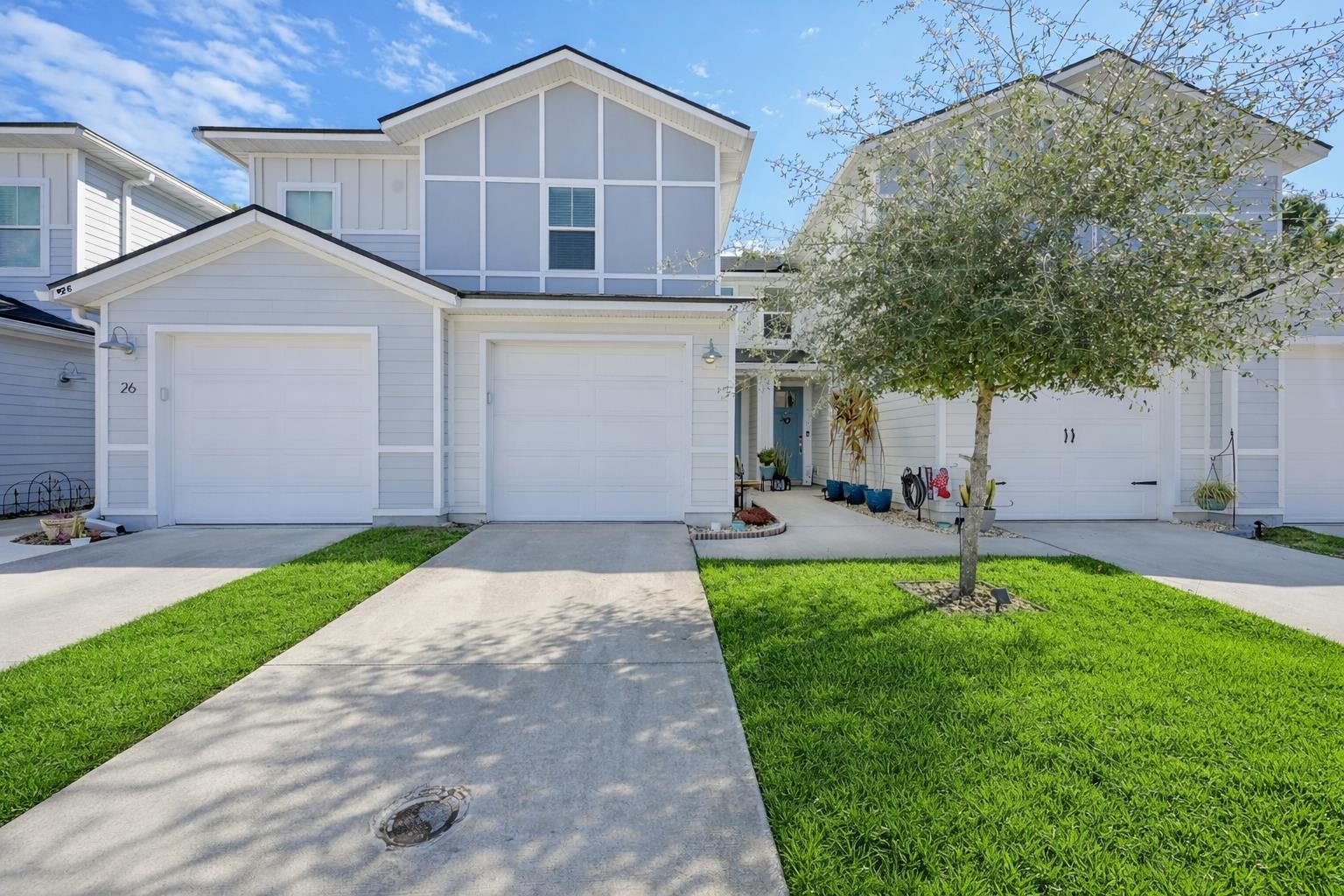 View of front of property featuring board and batten siding, concrete driveway, a garage, and a front yard