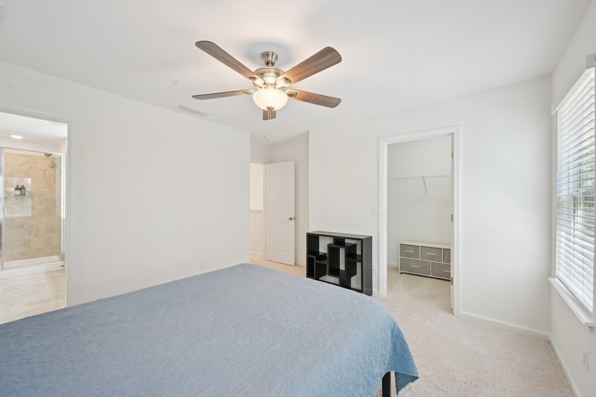 22 Ridge Lake Road St. Augustine, FL 32086 - Photo 14 of 31 Bedroom featuring a spacious closet, light carpet, a ceiling fan, and ensuite bathroom