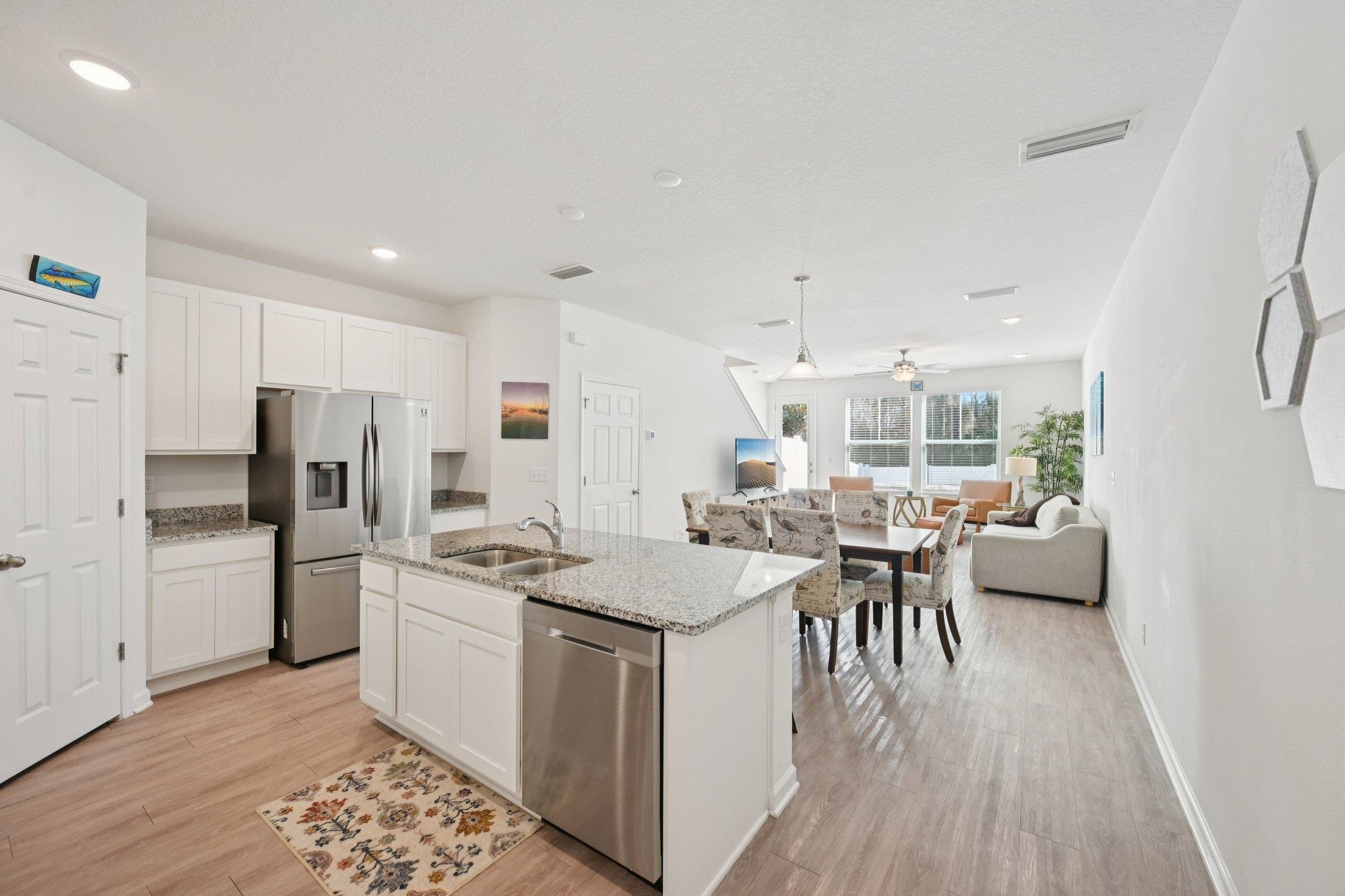 22 Ridge Lake Road St. Augustine, FL 32086 - Photo 3 of 31 Kitchen featuring white cabinets, stainless steel appliances, light stone countertops, an island with sink, and recessed lighting