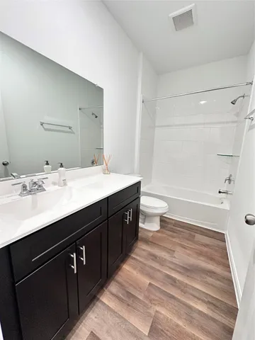 a bathroom with a double vanity sink toilet and shower