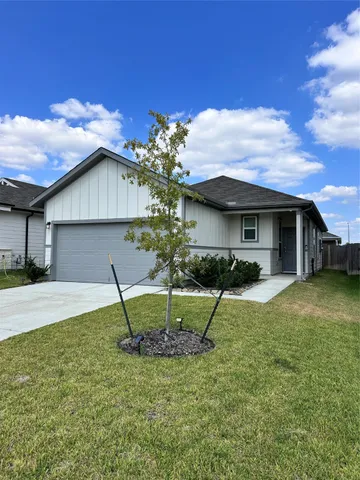 a view of a house with a yard and table and chairs under an umbrella