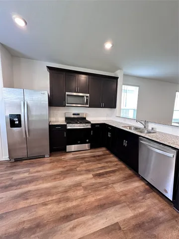 a large kitchen with cabinets and stainless steel appliances