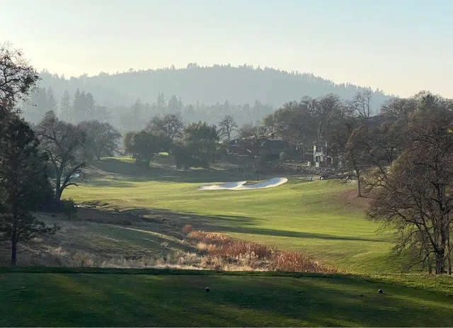 a dining room with wooden floor a chandelier a glass table and chairs