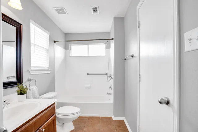 a bathroom with a sink a toilet and a large mirror