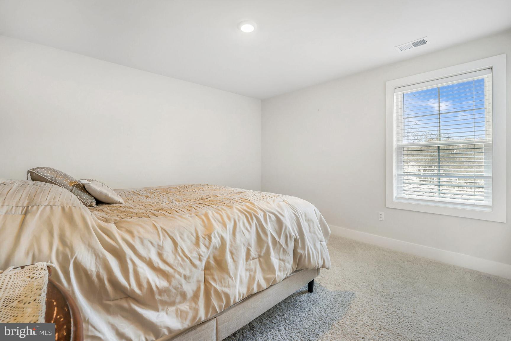 23420 Woodfield Road Gaithersburg, MD 20882 - Photo 30 of 50 a bed sitting in a bedroom next to a window