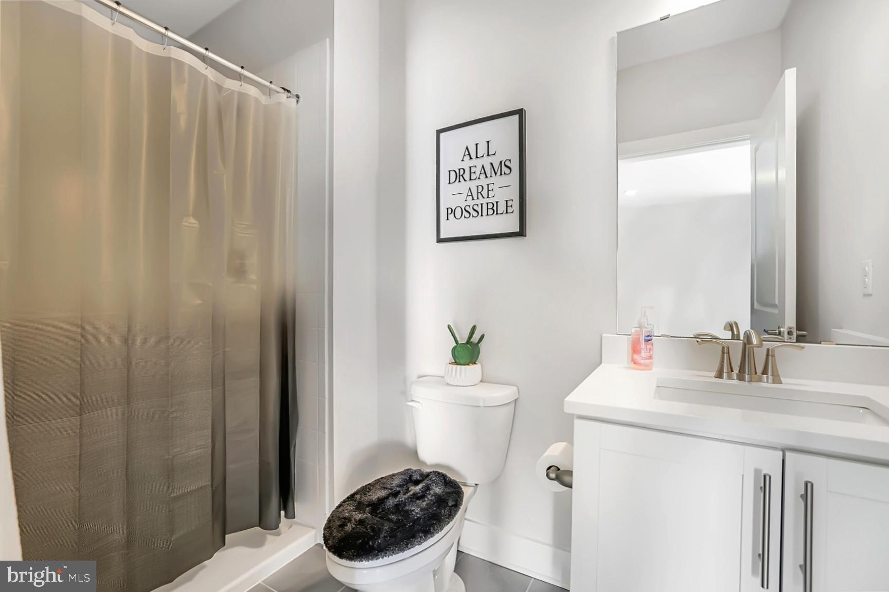 23420 Woodfield Road Gaithersburg, MD 20882 - Photo 39 of 50 a bathroom with a sink a toilet and shower curtain