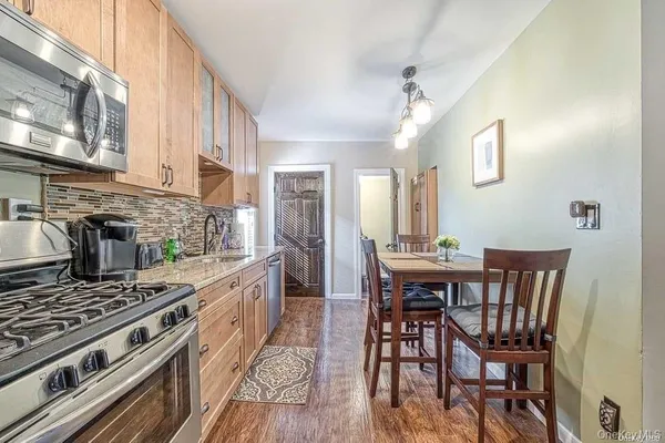 a kitchen with stainless steel appliances a table chairs and a stove