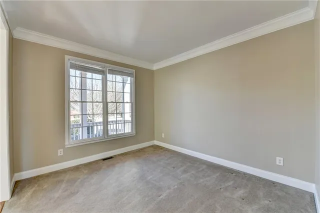 an empty room with windows a fireplace and wooden floor