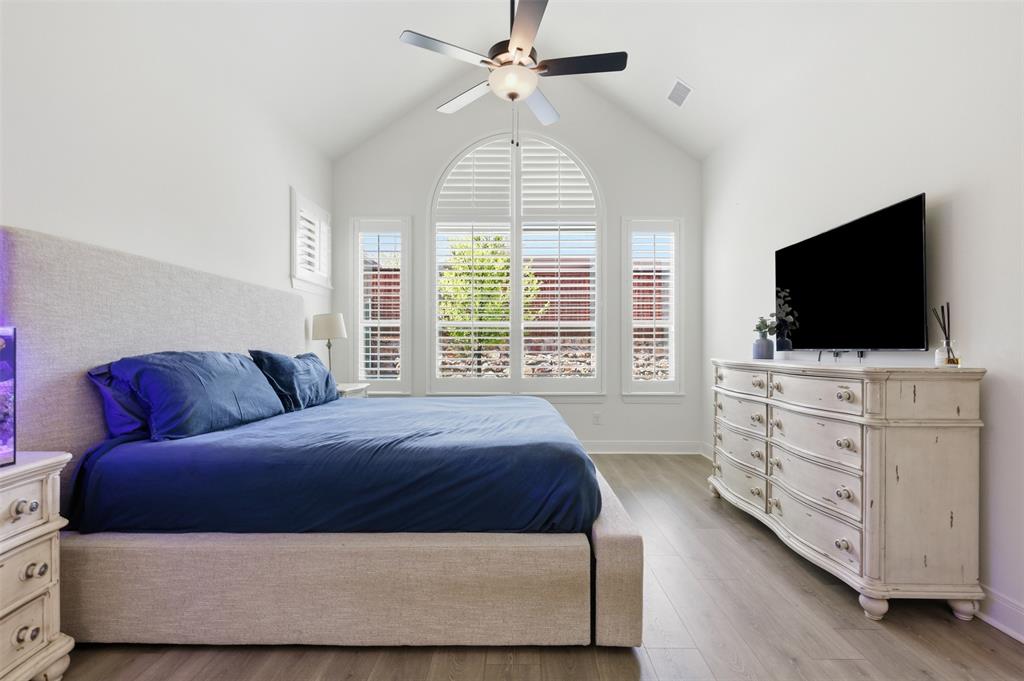 15413 Short Rdg Lane Fort Worth, TX 76008 - Photo 33 of 39 Vaulted ceiling room featuring wood-finish flooring, an arched window, a ceiling fan, and plantation shutters